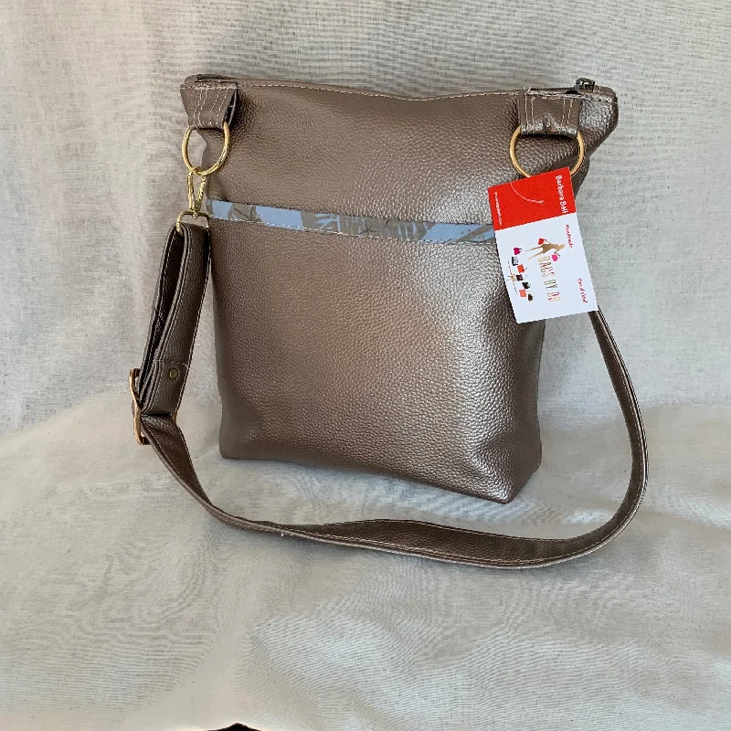 Convertible crossbody bag that can be worn as a shoulder bagMetallic vinyl crossbody with exterior slip pockets and interior zip pockets. Convertible crossbody bag that can be worn as a shoulder bagMetallic vinyl crossbody with exterior slip pockets and interior zip pockets.